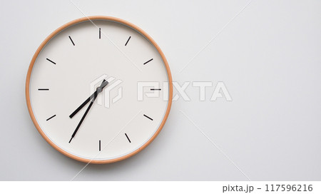 Minimalist wooden Wall Clock on White Wooden Surface with Space for Text.  Time Set at 19.35/07.35 117596216