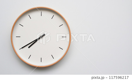 Minimalist wooden Wall Clock on White Wooden Surface with Space for Text. Time Set at 19.40/07.40 117596217