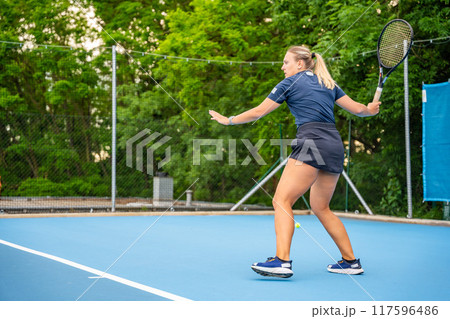 Professional female tennis player playing the tennis on outside court Professional female tennis player playing the tennis on outside court 117596486
