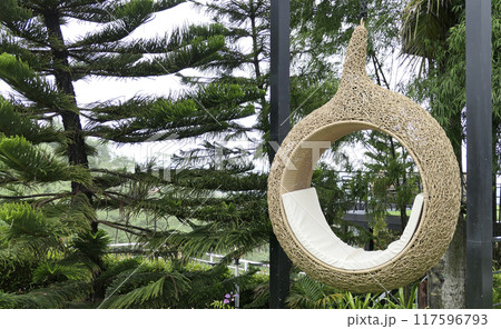 A wicker armchair in the form of a cocoon suspended in cafe A wicker armchair in the form of a cocoon suspended in cafe 117596793