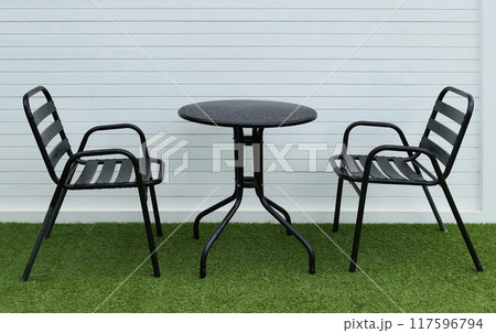 black chairs and table in lawn of garden black chairs and table in lawn of garden 117596794