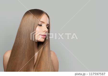 Stylish young woman model with modern make-up and long straight smooth hairstyle standing  117597587