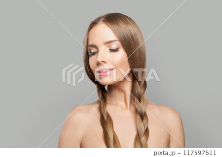 Smiling female model brunette with long hair and natural make-up posing isolated on white background 117597611