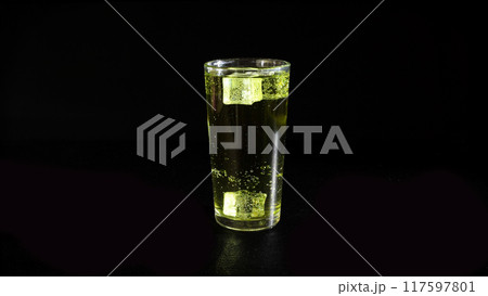 Lemonade with Rising Bubbles and Ice Cubes in Glass on a Black Background Lemonade with Rising Bubbles and Ice Cubes in Glass on a Black Background 117597801