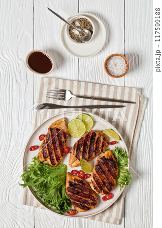 grilled chicken breasts wrapped in bacon on plate 117599188