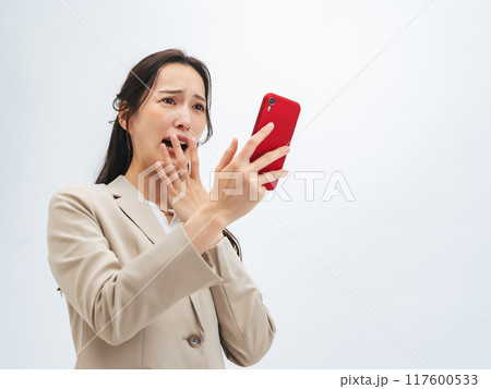 スマホを見て驚く女性 スマホを見て驚く女性 117600533