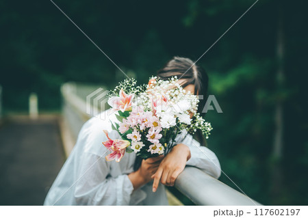 ブーケで顔を隠す白いワンピースの女の子 ブーケで顔を隠す白いワンピースの女の子 117602197
