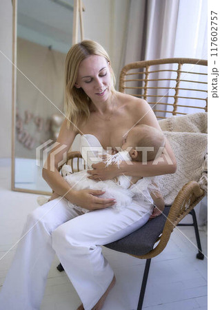 mother breastfeeding her baby, minimalist stylish interior, pastel colors 117602757