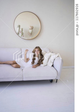 beautiful pre-teen girl in white clothes in a stylish minimalist interior beautiful pre-teen girl in white clothes in a stylish minimalist interior 117602916