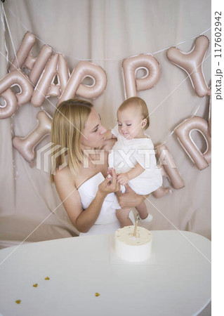 baby girl tries her first birthday cake with mom and pre-teen sister baby girl tries her first birthday cake with mom and pre-teen sister 117602942