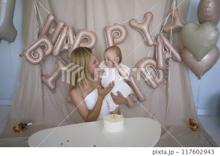 baby girl tries her first birthday cake with mom and pre-teen sister baby girl tries her first birthday cake with mom and pre-teen sister 117602943