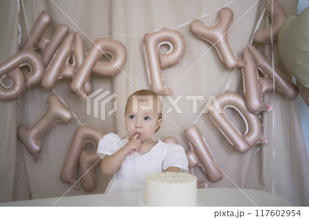 baby girl tries her first birthday cake with mom and pre-teen sister baby girl tries her first birthday cake with mom and pre-teen sister 117602954