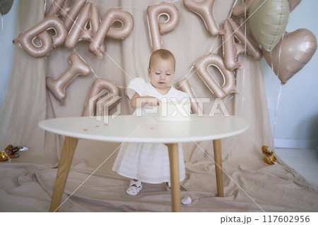 baby girl tries her first birthday cake with mom and pre-teen sister 117602956