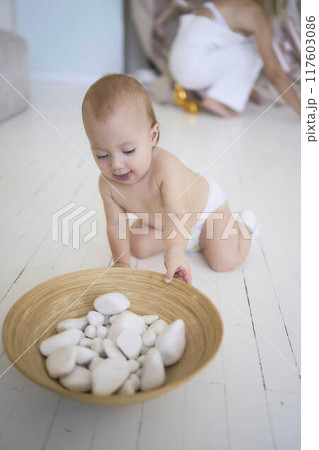 photo session on the first birthday of a baby girl, baby play with decorative rocks photo session on the first birthday of a baby girl, baby play with decorative rocks 117603086