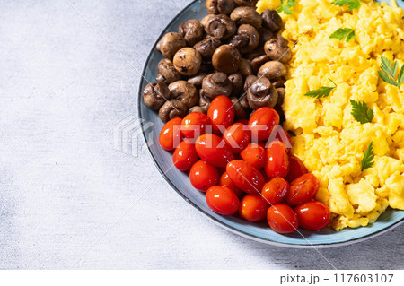 Homemade scrambled eggs with mushrooms and cherry tomatoes Homemade scrambled eggs with mushrooms and cherry tomatoes 117603107