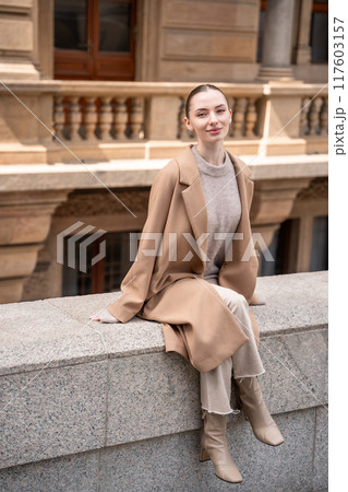 Young beautiful woman wearing coat walking in the city centre of Prague, Europe 117603157