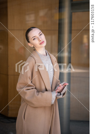 Young beautiful woman wearing coat walking in the city centre of Prague, Europe 117603158
