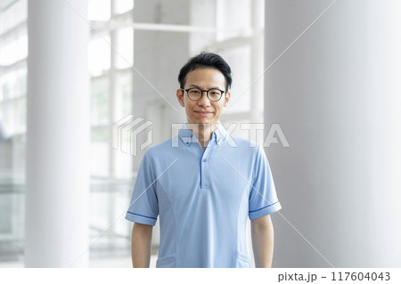 ブルーのポロシャツを着たカメラ目線の30代の男性　施設スタッフ　イメージ 117604043