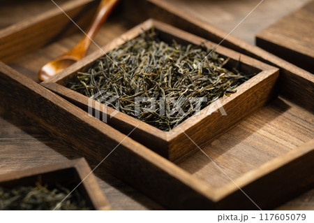 Green tea in wooden box and barrel on wooden board Green tea in wooden box and barrel on wooden board 117605079