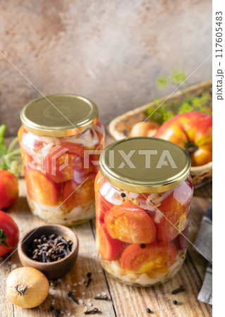 Healthy homemade fermented food. Salted pickled tomatoes and onions preserved canned in glass jar. Home economics, autumn harvest preservation. Copy space. 117605483