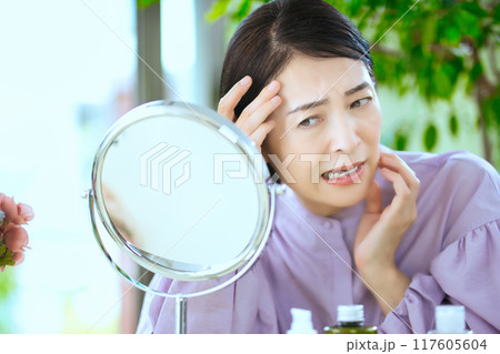 髪の毛を気にするミドル女性 117605604