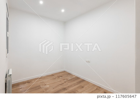 White room with wooden floor, recessed lighting, contemporary and peaceful design 117605647