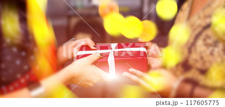 A woman is holding a red box with a white ribbon on it A woman is holding a red box with a white ribbon on it 117605775