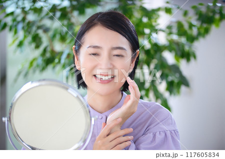 リビングでスキンケアをするミドル女性 117605834