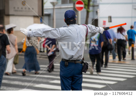 歩行者の横断を誘導をする交通警備員 歩行者の横断を誘導をする交通警備員 117606412