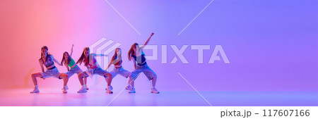 Banner. Group of young girls dancing in neon light against gradient pink background with negative space to insert text. 117607166
