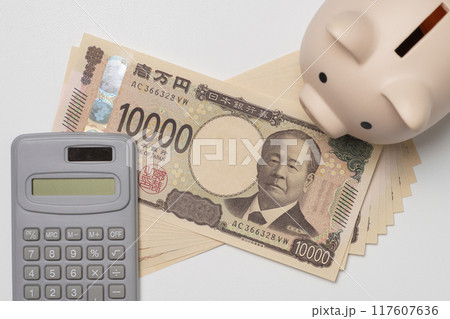 新紙幣で10万円と貯金箱と電卓を俯瞰で 新紙幣で10万円と貯金箱と電卓を俯瞰で 117607636