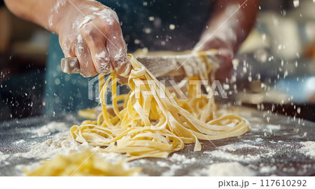 Hand-cutting fresh pasta noodles. Hand-cutting fresh pasta noodles. 117610292