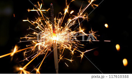 Sparkler emitting bright sparks in the dark night. Sparkler emitting bright sparks in the dark night. 117610388