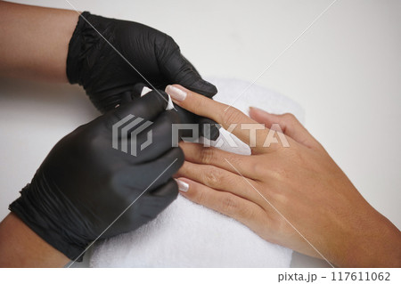 Administering a Manicure With Black Gloves on 117611062