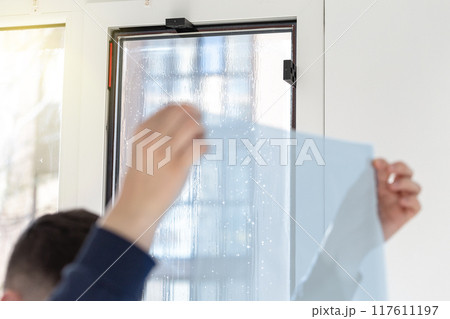 Installation of tinted film. Ultraviolet and energy afficiency concept. 117611197