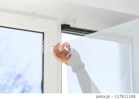 Installation of tinted film. Ultraviolet and energy afficiency concept. Installation of tinted film. Ultraviolet and energy afficiency concept. 117611198