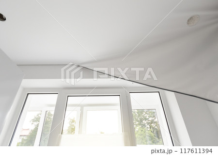 Installs a stretch ceiling 117611394