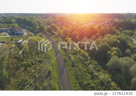Railway through summer forest. Aerial view. Sunset time Railway through summer forest. Aerial view. Sunset time 117611410