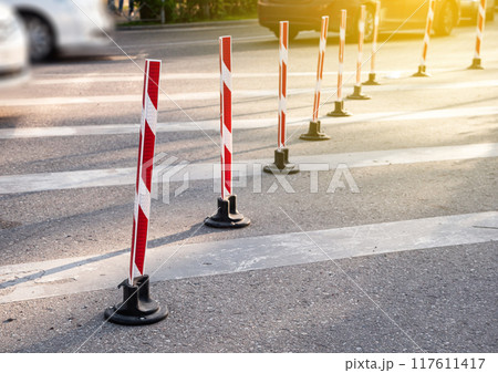 Road poles with red stripes for pakring and drive control 117611417