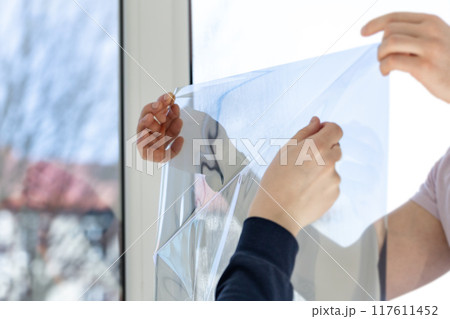 Installation of tinted film. Ultraviolet and energy afficiency concept. 117611452