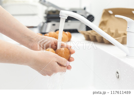 Washing chicken eggs under water Washing chicken eggs under water 117611489