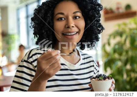 Woman in striped blouse enjoying delicious tiramisu 117612417