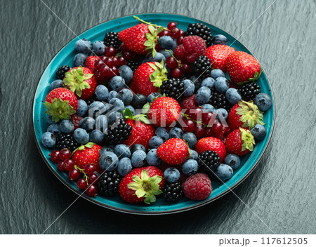 Mix of ripe colorful berries in bowl photography . Blueberry , strawberry , raspberry , blackberry and red currant . Top view Mix of ripe colorful berries in bowl photography . Blueberry , strawberry , raspberry , blackberry and red currant . Top view 117612505