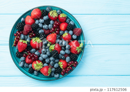 Mix of ripe colorful berries in bowl photography . Blueberry , strawberry , raspberry , blackberry and red currant . Top view Mix of ripe colorful berries in bowl photography . Blueberry , strawberry , raspberry , blackberry and red currant . Top view 117612506