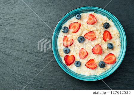 Homemade breakfast . Oatmeal with milk and berries . Top view 117612526