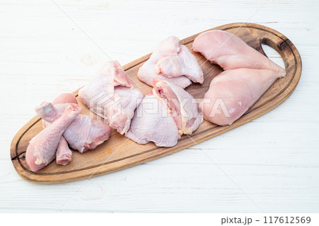 Raw mixed chicken meat parts for cooking on rustic background Raw mixed chicken meat parts for cooking on rustic background 117612569