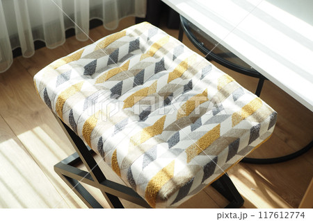 A Stylish Geometric Patterned Stool that Features Warm Tones for A Cozy Atmosphere A Stylish Geometric Patterned Stool that Features Warm Tones for A Cozy Atmosphere 117612774