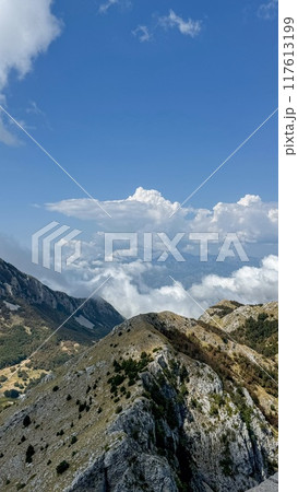 Mountain peaks surrounded by clouds 117613199