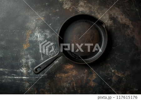 Empty cast-iron frying pan on rustic background, top view 117615176
