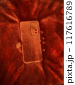 Phone mark on a fluffy blanket. Detailed print of a phone on a plush bedspread. Outline mark of a cellphone. 117616789